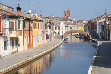 Fototapeta na wymiar View of the small Italian town Comacchio (Ferrara, Emilia Romagna region): traditional colored houses and canal for boats.