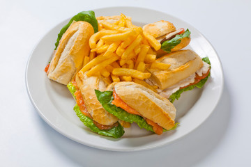 Different types of sandwiches with French fries on a white plate