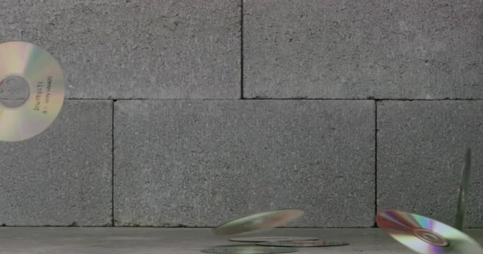 Compact discs falling and bouncing on concrete
