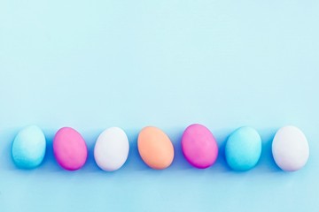 Row of colorful Easter eggs on blue background