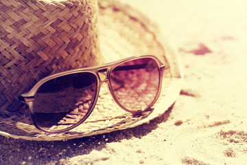 Summer or Vacation Concept. Beautiful Sunglasses with Straw Hat on Sand. Beach. Lifestyle. Toning.