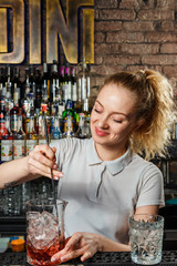 Woman bartender making an alcohol cocktail
