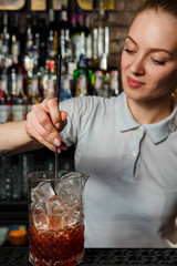 Woman bartender making an alcohol cocktail