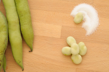 Close up on fava beans and salt, from above