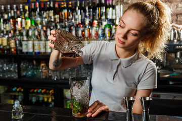 Woman bartender making an alcohol cocktail