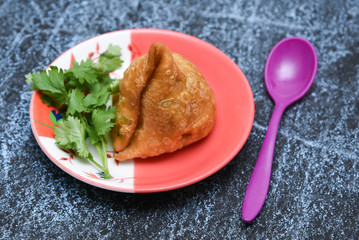 Fried Bombay samosa popular indian, asian and african deep fried snack with spicy chutney and mint. local street food in North India, Mumbai, Delhi, Rajasthan