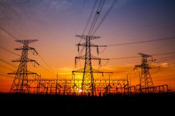 The silhouette of the evening electricity transmission pylon