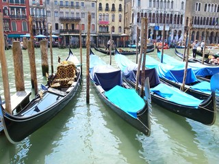Fototapeta na wymiar VENICE, ITALY - MAY 25, 2015 : many gondola parked in front of the canals waiting for a tourism ride.