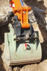 Fototapeta premium Bagger mit Baagerschaufel auf einer Baustelle