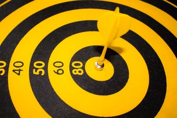 Success hitting target aim goal achievement concept background - yellow dart close up