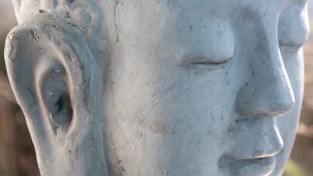 closeup of rotating stone head of buddha
