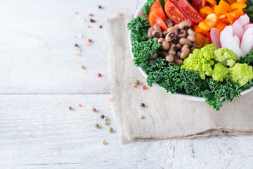 Healthy vegan buddha bowl with kale leaves and raw vegetables