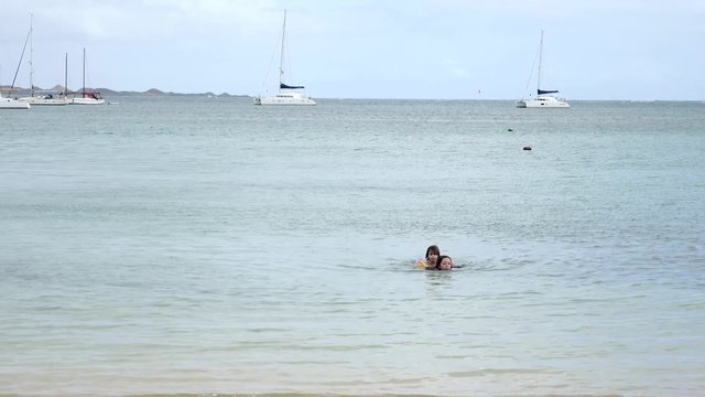 jeunes fille et sa petite sœur nageant dans le lagon
