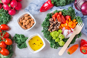 Healthy vegan buddha bowl with kale leaves and raw vegetables