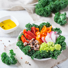 Healthy vegan buddha bowl with kale leaves and raw vegetables