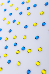 Precious sparkling rhinestones blue and yellow colors on a white acril background.