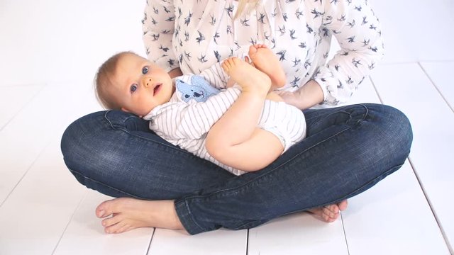 baby mit gro&szlig;en blauen augen und blonden haaren im bett kuschelt mit mama