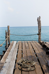 Fototapeta premium Rope on wood dock by the sea in Thailand