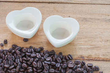 heart shape of cup on wood and coffee bean