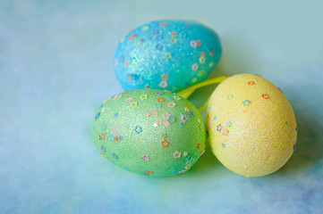 Three colorful handmade easter eggs on blue background
