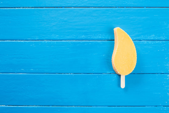 Yellow Popsicles In Blue Wood Background