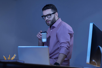 Serious handsome man holding a cup with coffee