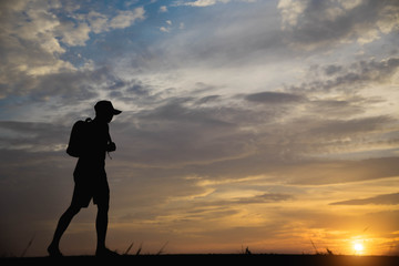 Fototapeta premium Silhouette of a man happy walking at sunset.