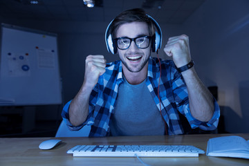 Cheerful delighted man winning the computer game