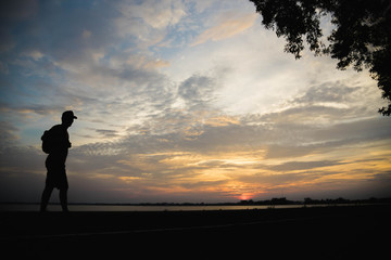 Fototapeta premium Silhouette of a man happy walking at sunset.