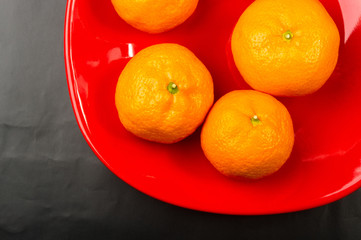 tangerines in a red plate