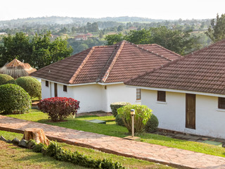 Fototapeta na wymiar Cottages with lawn and decorative plants before. Jinja, Uganda, Eastern Africa. 
