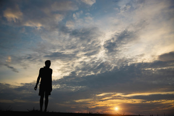 Obraz premium Silhouette of a man happy at sunset.