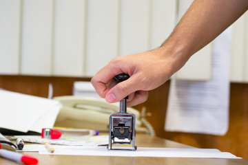  hand putting stamp on a document, close up