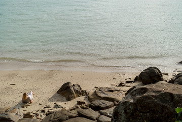 Fototapeta na wymiar Young blonde woman on a beach in beach dress