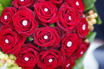 Bouquet con rosa rosse e gioiello in mezzo