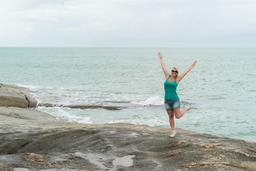 Young blonde woman staying near sea