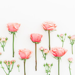 Floral pattern with pink roses, branches and buds on white background. Flat lay, top view. Floral background.