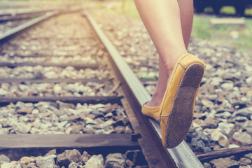 Asian young girl walking along railway station, walking on the train track