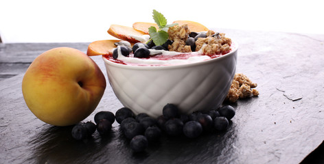 breakfast smoothie bowl with blueberries, peach and granola