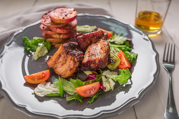 Hot Meat Dishes. Pork ribs grilled with salad and apples on a plate.