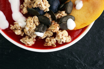 breakfast smoothie bowl with blueberries, peach and granola