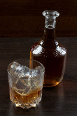 Glass and bottle whiskey on wooden table
