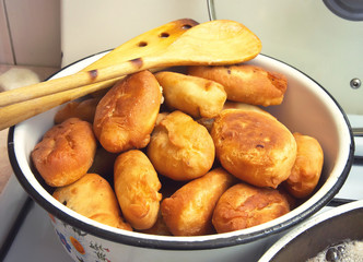 Жаренные пирожки с картошкой и мясом на в миске на домашней плите 