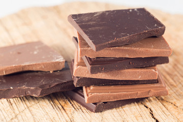 Milk and dark chocolate pyramid on wooden table. Beautiful