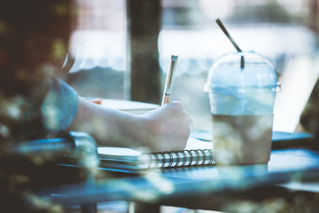 Asia teenage hipster in sitting alone at cafe with notebook
