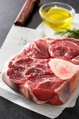 Raw meat and ingredients on black slate 
