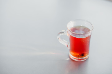 a glass of steaming hot tea on the table.