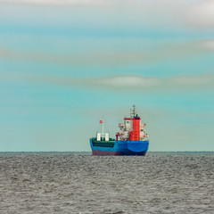 Naklejka na ściany i meble Blue cargo ship entering the Baltic sea. Riga, Europe