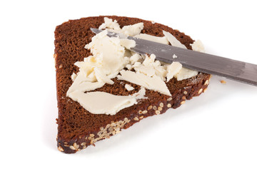 slice of black bread with sesame seeds and butter isolated on white background