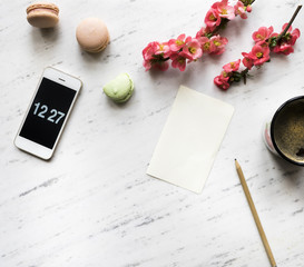 Flowers with smartphone and notebook on marble background